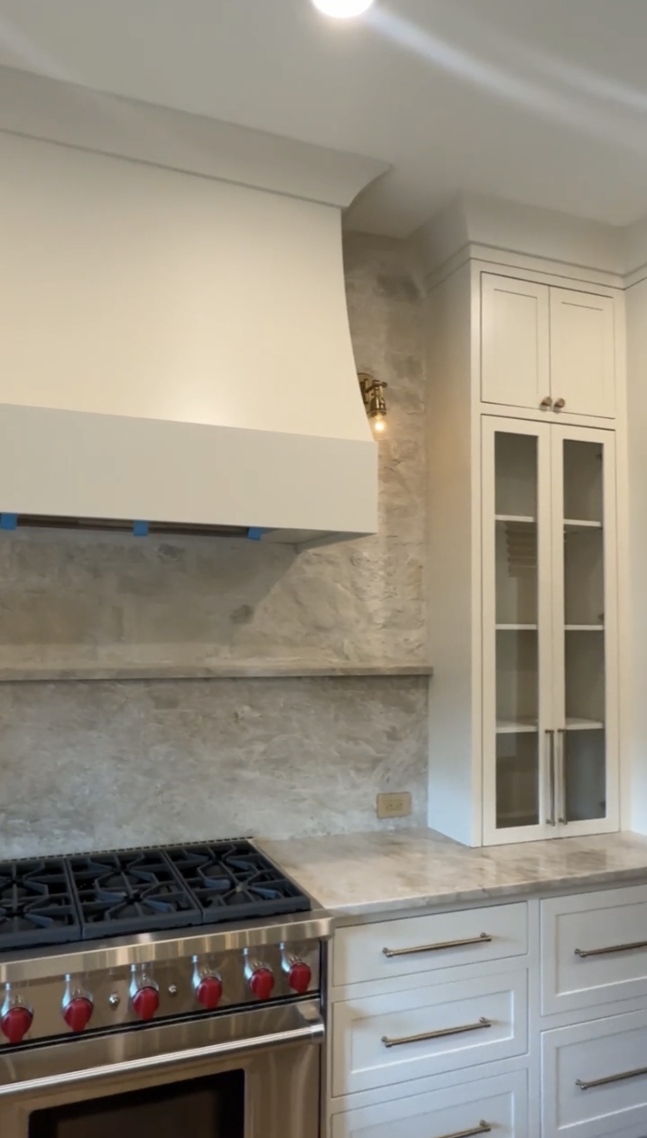 Custom kitchen range hood and glass-front cabinetry