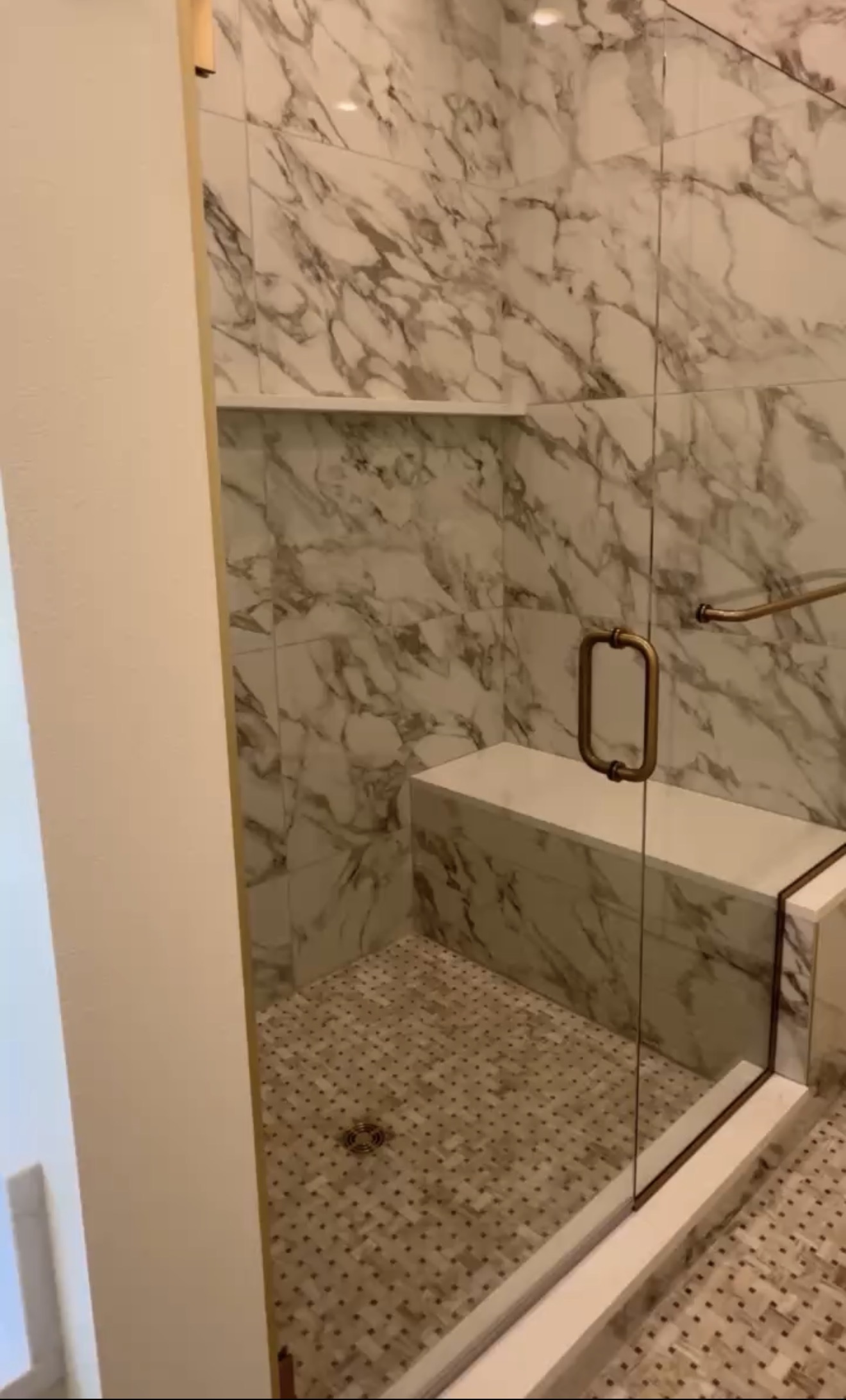 Marble tiled shower with brass fixtures