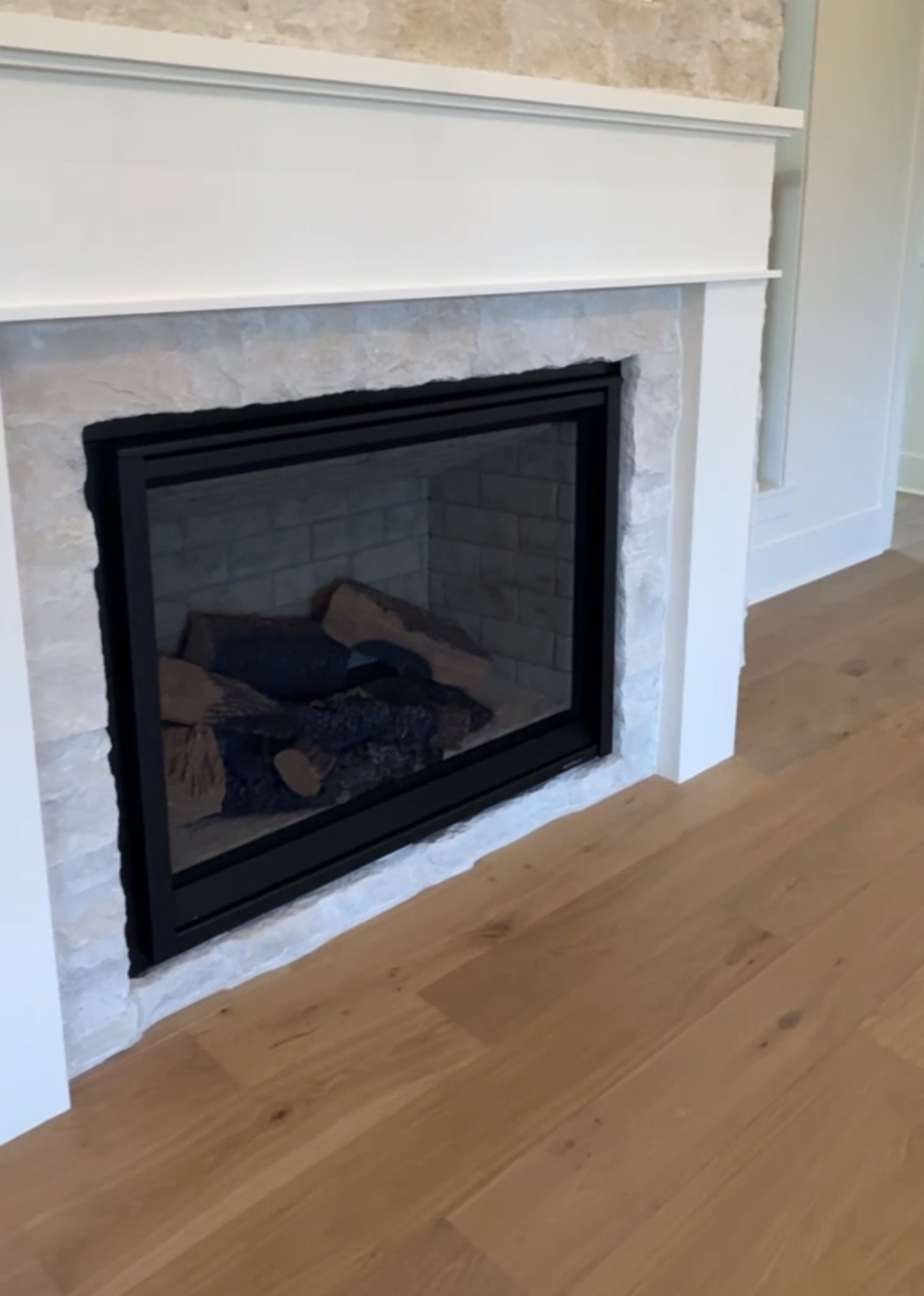 Stone fireplace and white mantel